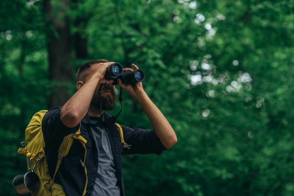 10-Day Tanzania Birding Expedition 5 A hiker man walking in the forest using binoculars